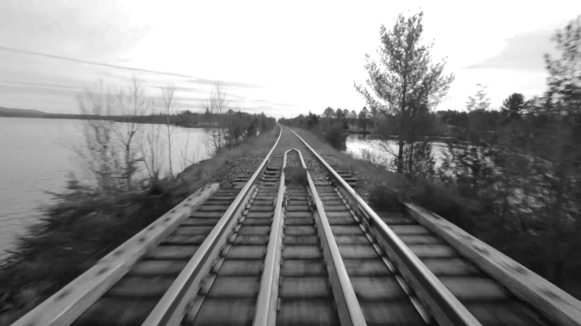 Railway tracks crossing water in a scene from MONUMENT.